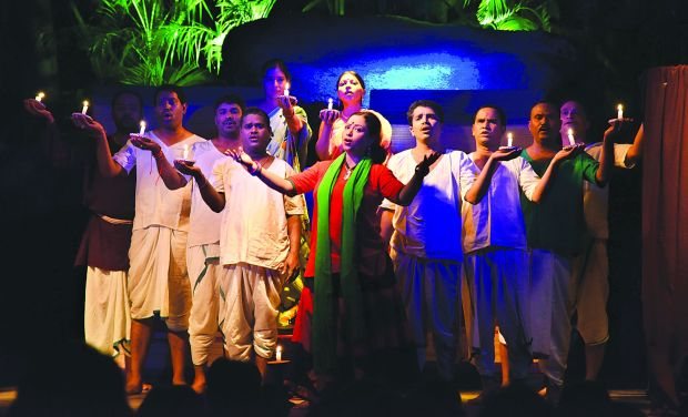 Actors in costume on a stage lit in blue